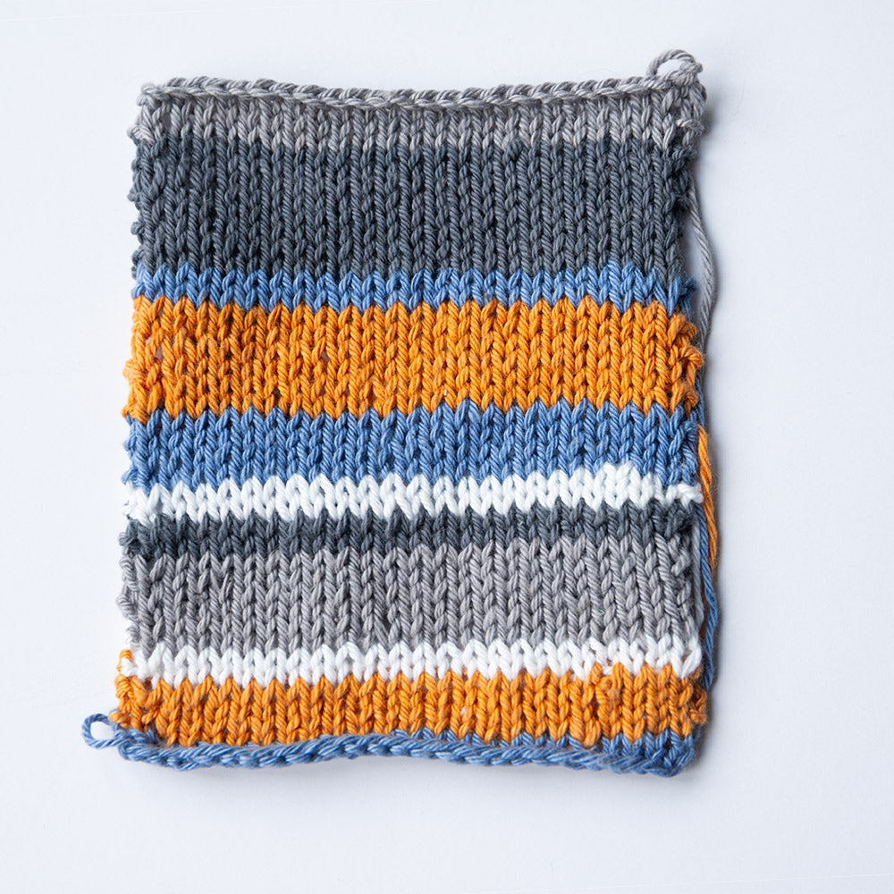 Gebreid kleurstaal van kleuroptie 2 met grijs, denimblauw, curry en wit