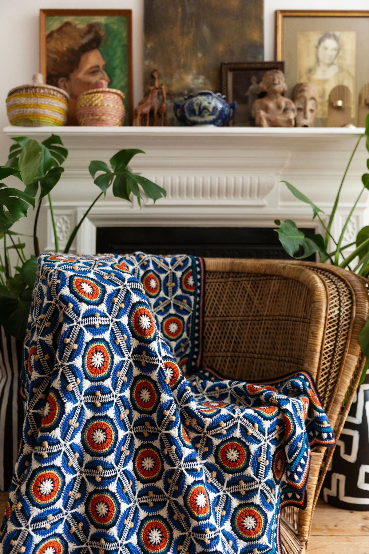 Sevilla Blanket van Jane Crowfoot gedrapeerd in interieur met boek