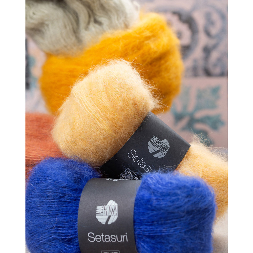 Lana Grossa Setasuri 062 Umbra - sfeerfoto met gestapelde bollen Lana Grossa Setasuri in oranje, geel en blauw - sfeerfoto 32