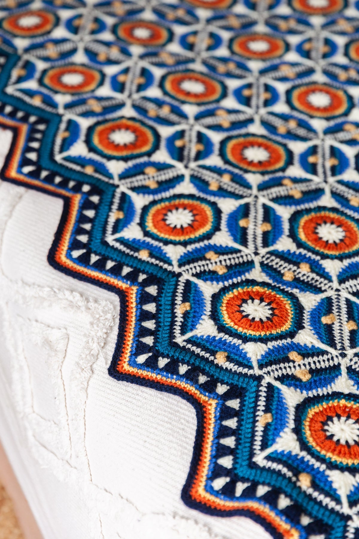 Detail van Sevilla Blanket met blauwe en oranje zeshoekige haakmotieven